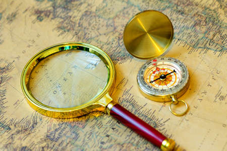 compass and magnifying glass gold color on the old mapの写真素材