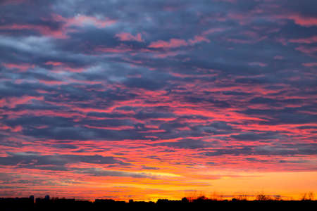 The Contrast the sky blood red sunset silhouettes of city buildings black clouds natural phenomenon.の写真素材