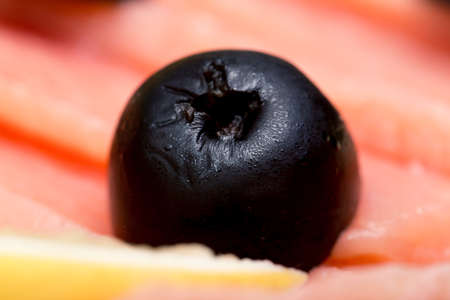 sliced red fish salmon greens lemon black olives close-up, macroの写真素材
