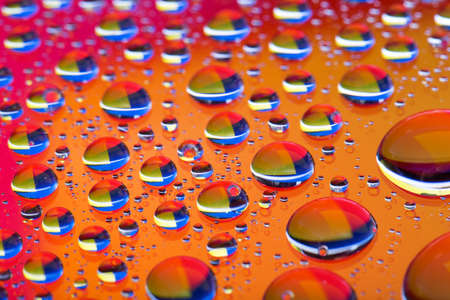 The Abstract orange red background with gradient color water drops on glass with reflection, bockeh, macroの写真素材