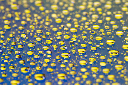 the Abstract blue-yellow background with gradient color water drops on glass with reflection, bockeh, macroの写真素材