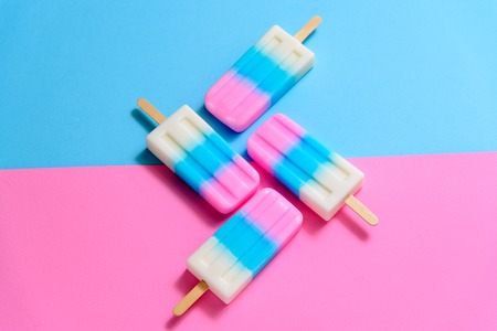 Fruit Ice cream stick , popsicle , ice pop or freezer pop with copyspace on blue and pink pastel background or textureの写真素材