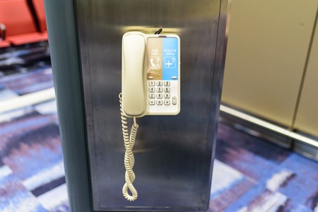 The telephone was hanging on a pole in the airport. Used for help or inquiries.の写真素材