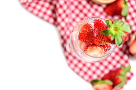 Glass of strawberry cocktail soda placed on a plaid tablecloth isolated on white background.の写真素材