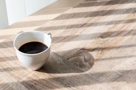A cap of black coffee put on wooden table.の写真素材