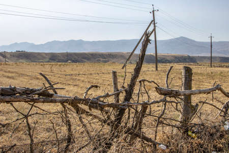 old fence of sticks on the background of the mountains
