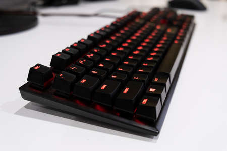 a gaming keyboard and mouse shot over on the white table.