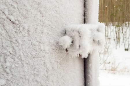 metal door and door handle and keyhole are covered with frost. severe frosts. door freezes. icy handle and lock covered with snowflakesの写真素材