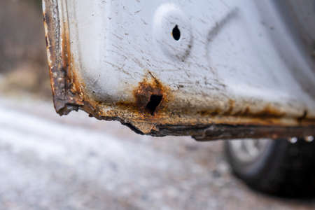 Hard corrosion and rust on the body and doors of the car whiteの写真素材