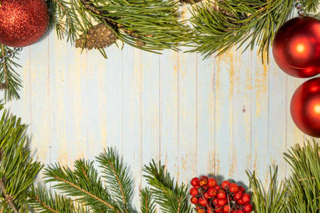 Christmas and New Year wooden background with light . Fresh spruce twig and bumps. red garlands....