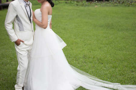 Happy bride and groom on the green grass in the wedding dayの写真素材
