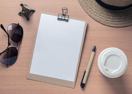 Notebook and travel objects on wooden table background with vintage filterの写真素材