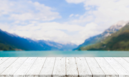 Wood table top and blurred lake & mountain background - can used for display or montage your products.の写真素材