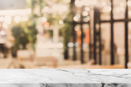 Stone table top and blurred bokeh cafe and coffee shop interior background with vintage filter - can used for display or montage your products.の写真素材