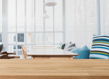 Wood table top and blurred bokeh cafe and coffee shop interior background with vintage filter - can used for display or montage your products.の写真素材