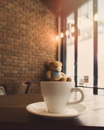 A cup of cappuccino coffee on wooden table in coffee shop background with vintage filterの写真素材