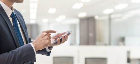 Business man using smart phone in office space background and copy space.の写真素材