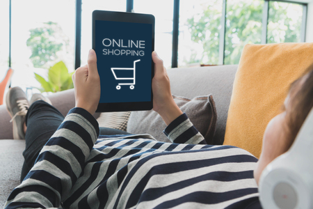 Young beautiful Asian woman laying in sofa and shopping online with tablet at home background.Concept of people using technology.Vintage toneの写真素材