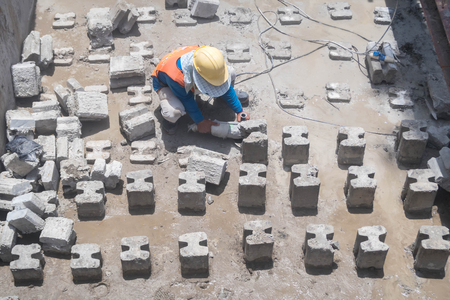 Construction workers are cutting concrete piles with power machine tools at construction site.の写真素材