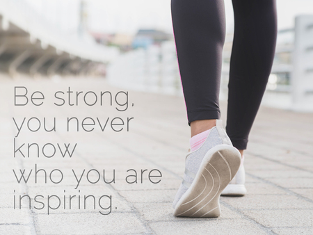 Inspirational quote "Be strong you never know who you are inspiring" on blurred road and pair of legs background with vintage filterの写真素材