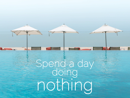 Inspirational quote "Spend a day doing nothing" on swimming pool by the sea in the morning. の写真素材