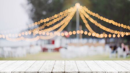 Empty wood table top on abstract blurred restaurant and nightclub party lights background - can be...