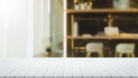 Empty white ceramic mosaic table top and blurred bokeh cafe and restaurant background with vintage filter - can used for display or montage your products.の写真素材