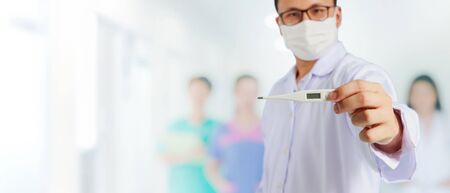 Asian medical male Doctor wear a mask to prevent Coronavirus 2019 and standing and raising hand to...
