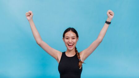 Portrait of confident beautiful asian fitness woman feeling happy and rise her hand up after...