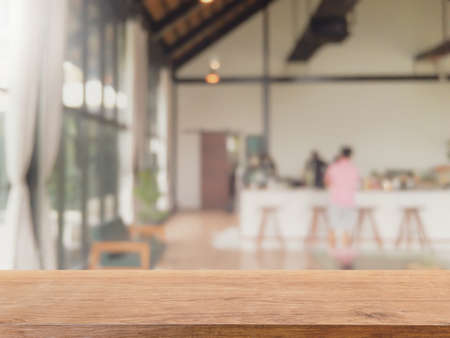 Empty wood table top and blurred coffee shop, cafe and restaurant interior background - can used for...