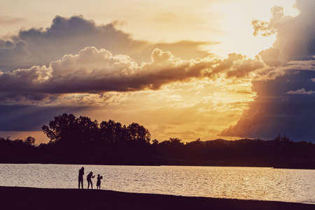 Silhouette people standing at lake with mountain and sunset sky scenic landscape background with copy space.の写真素材