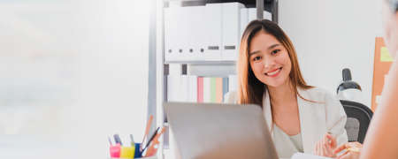 Asian beautiful empower woman smiling with friend working at meeting room in office interior...