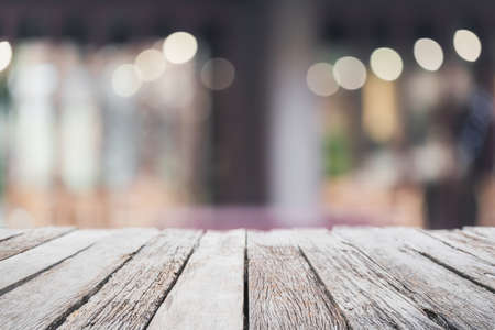 Empty wood table top and blurred coffee shop and restaurant interior background - can used for...