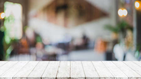 Empty wood table top and blurred coffee shop and restaurant interior background - can used for display or montage your products.の写真素材