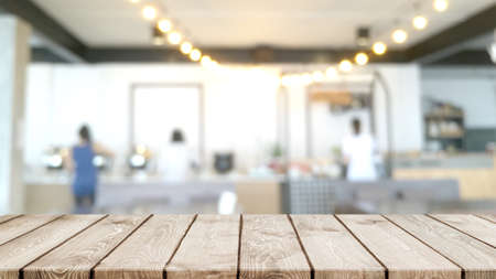 Empty wood table top and blurred coffee shop, cafe and restaurant interior background - can used for...
