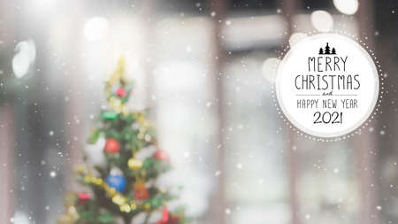 Christmas and Happy new year 2021 on blurred bokeh Christmas tree with snowfall banner background.の写真素材