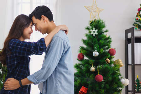 Young Asian couple lover dancing together in Christmas and Happy New Year holiday festival at home...