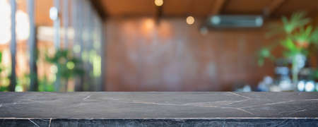 Empty black marble stone table top and blurred coffee shop, cafe and restaurant interior background - can used for display or montage your products.の写真素材