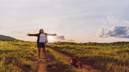 Asian woman standing at grass field with mountain and sunset sky scenic landscape background with...