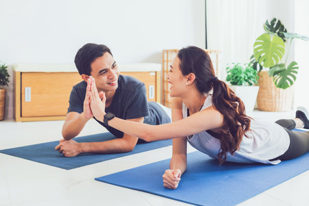 Asian young couple exercise together at home background.Concept of Exercise during the quarantine at...