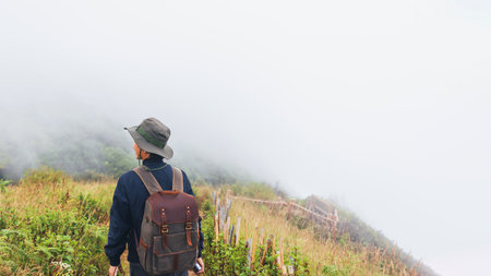 Traveler man standing on the top of mountain with white cloud fog in nature at Chang Mai, North of...