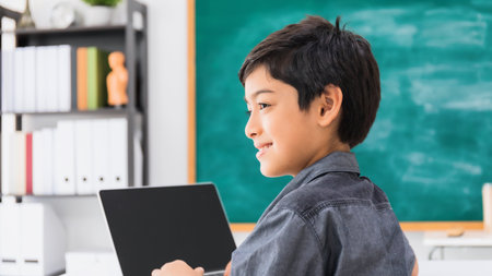 Asian happy school boy using laptop on black board background with smiling face.Creative education...