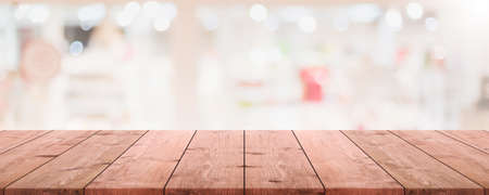 Empty wood table top and blurred coffee shop and restaurant interior background - can used for display or montage your products.の写真素材