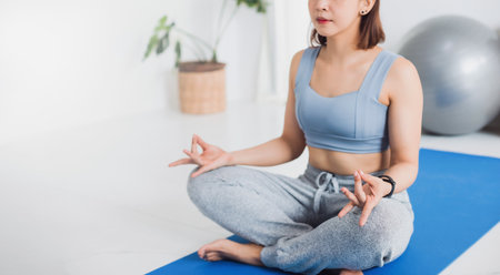 Asian young woman exercise and play yoga meditation at home background.