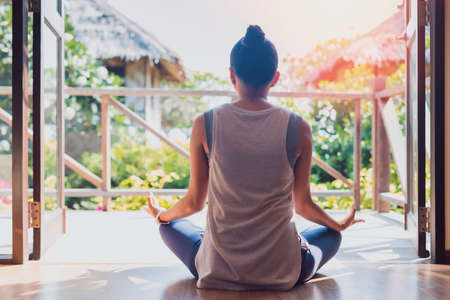 Asian beautiful woman exercise and play yoga at home.Concept of Exercise during the quarantine at home for preventing coronavirus and covid-19 infection.の写真素材