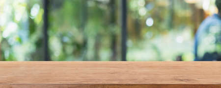 Empty wood table top and blurred coffee shop, cafe and restaurant interior background - can used for...
