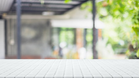 Empty white ceramic mosaic table top and blurred bokeh cafe and restaurant background with vintage filter - can used for display or montage your products.の写真素材