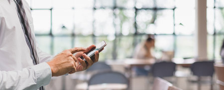 Businessman using smart phone in blur cafe interior space banner background and copy space.Concept of people shopping online technology.の写真素材