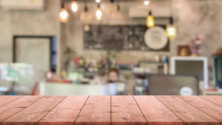 Empty wood table top and blurred coffee shop, cafe and restaurant interior background - can used for...