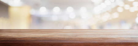 Empty wood table top and blurred coffee shop and restaurant interior background - can used for display or montage your products.の写真素材
